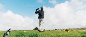 Golfers swing at Holywell Bay Par 3 Golf Course